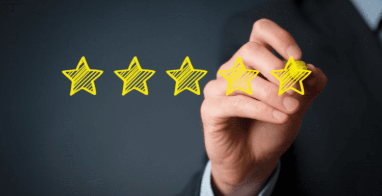 شخص يرسم 5 نجوم للدلالة على مراجعات العملاء المزيفة - fake customer reviews
